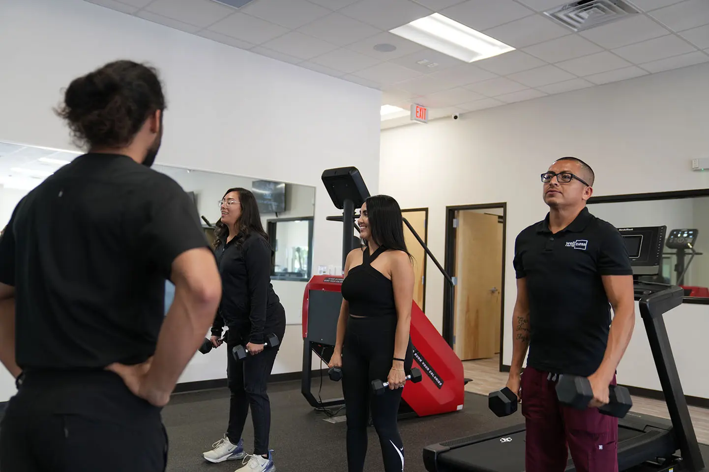 Trainer coaching clients during a weight management session at KM Wellness Center in El Paso